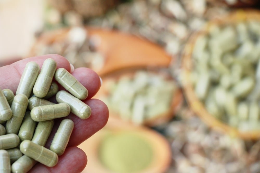 Moringa capsule for health on wood background