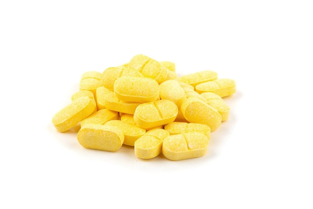 Vitamin C, yellow vitamin pills isolated on white background.